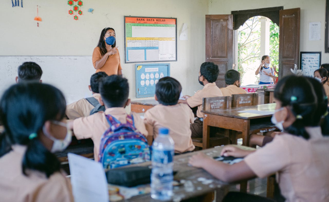 A classroom scene with students and a teacher wearing masks during a lesson.